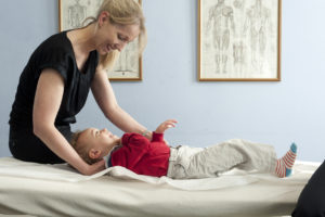 Female osteopath treating toddler